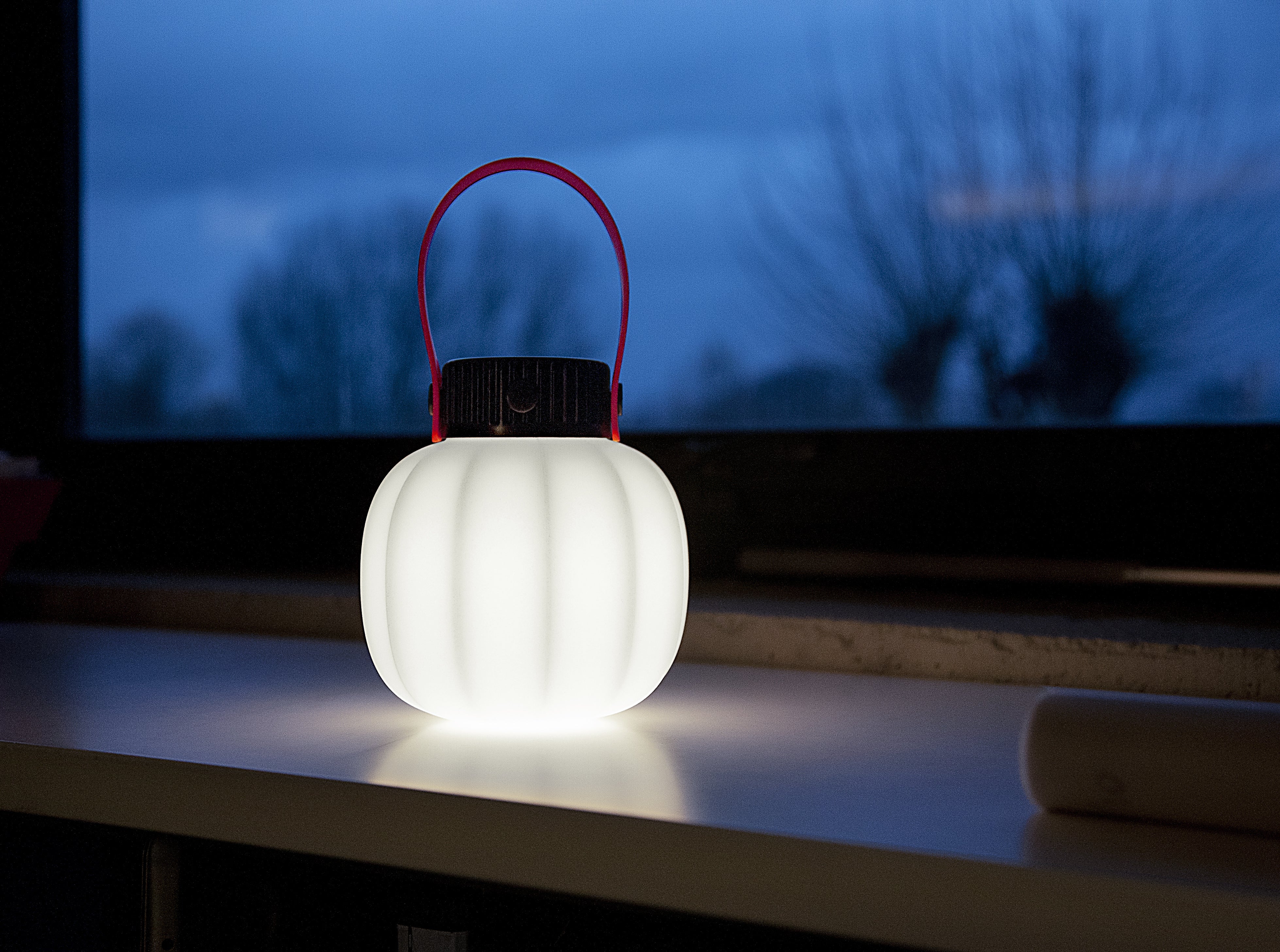 Portable outdoor lamp KIKI in white with a silicone handle.