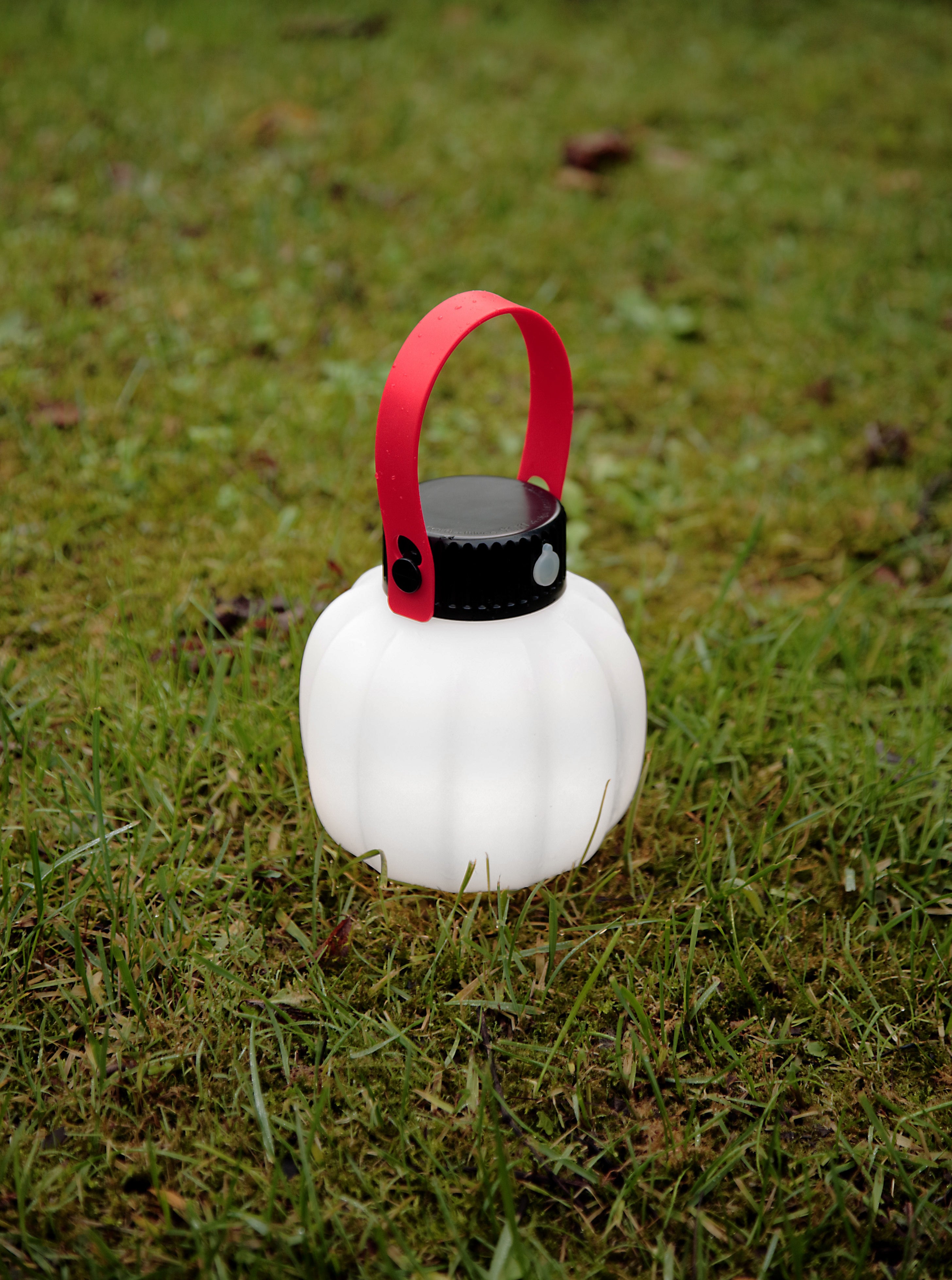 Portable outdoor lamp KIKI in white with a silicone handle.