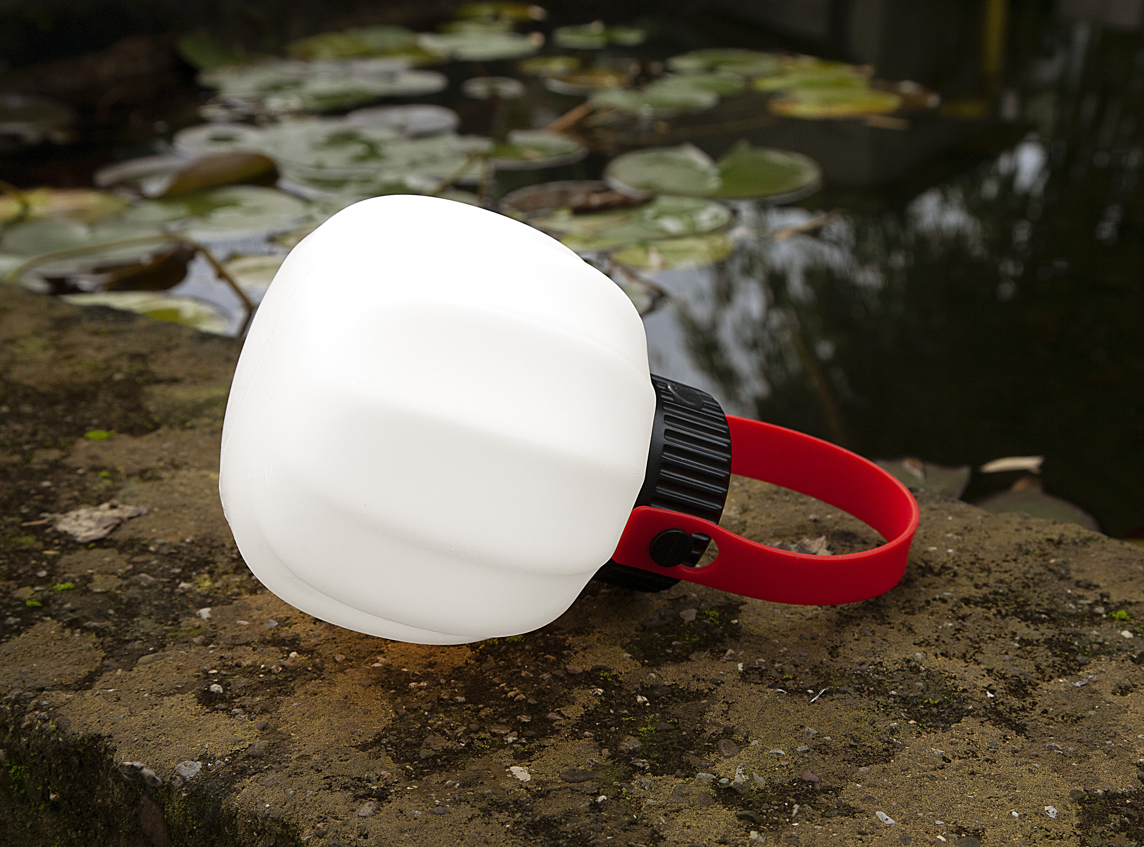 Portable outdoor lamp KIKI in white with a silicone handle.