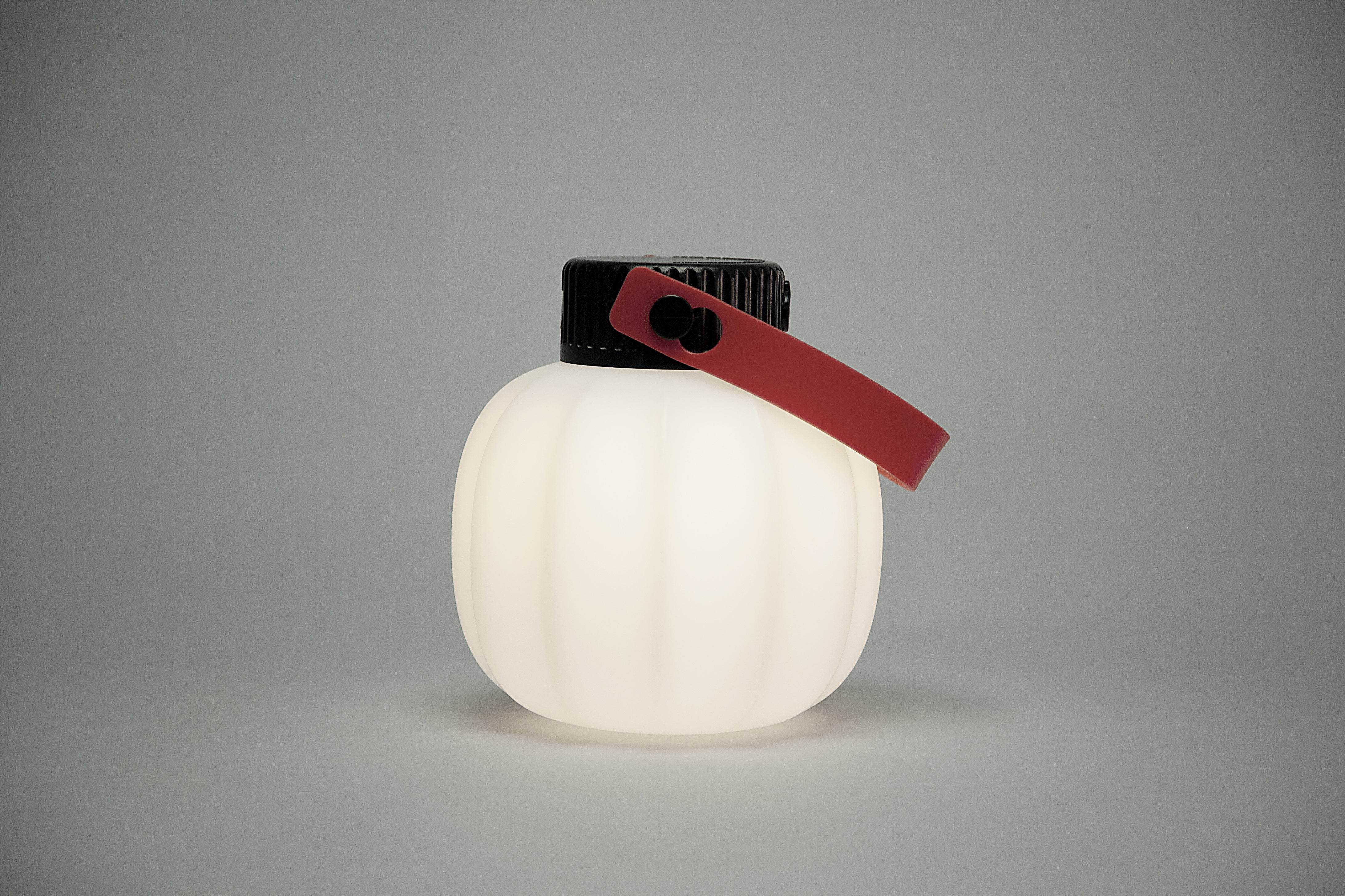 Portable outdoor lamp KIKI in white with a silicone handle.