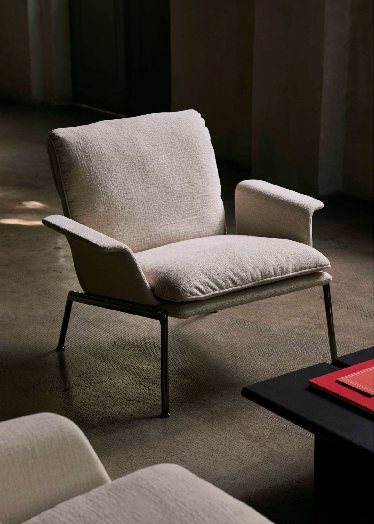 MUNO LN19 upholstered armchair with a dark aluminum base