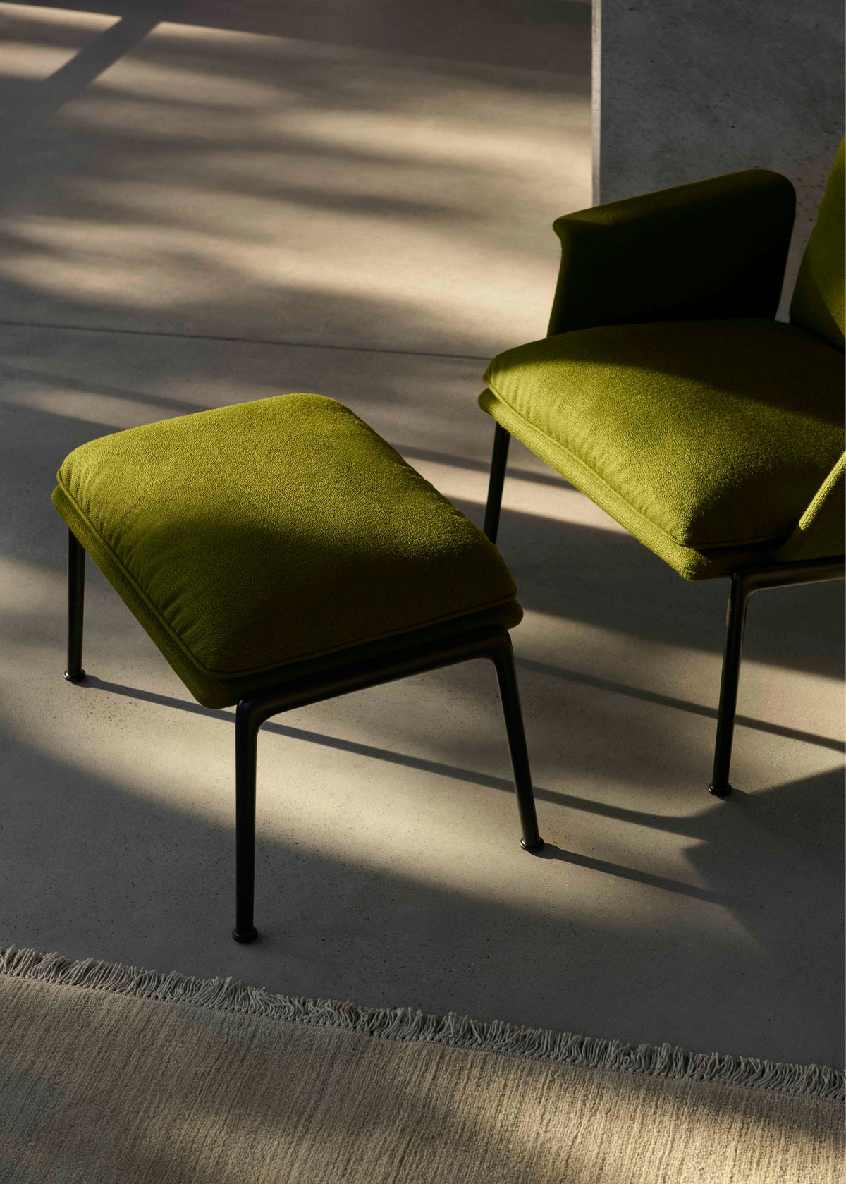 Upholstered MUNO LN20 footstool with a dark aluminum base