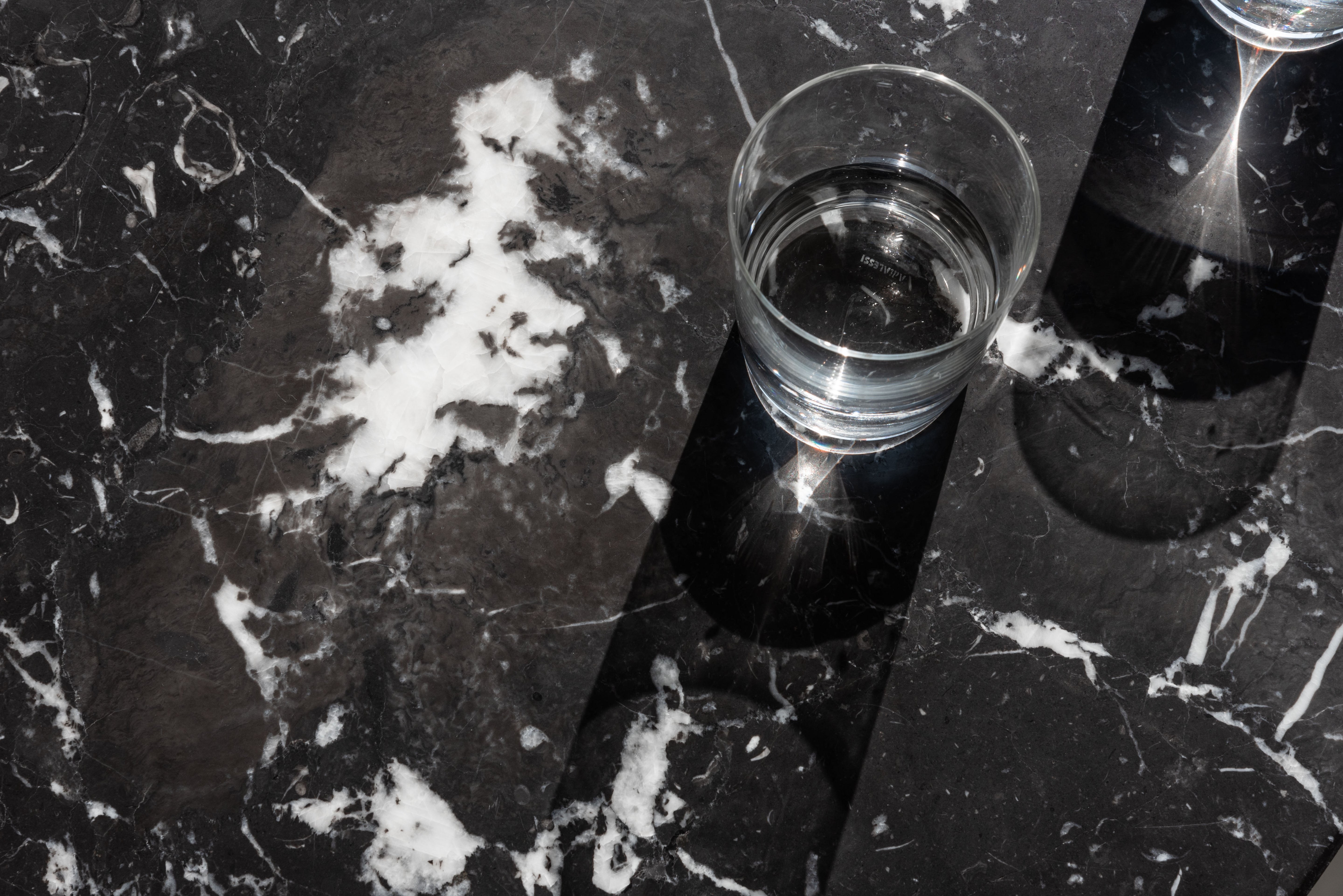 BRUT runder Tisch aus schwarzem Marmor mit rotem Sockel