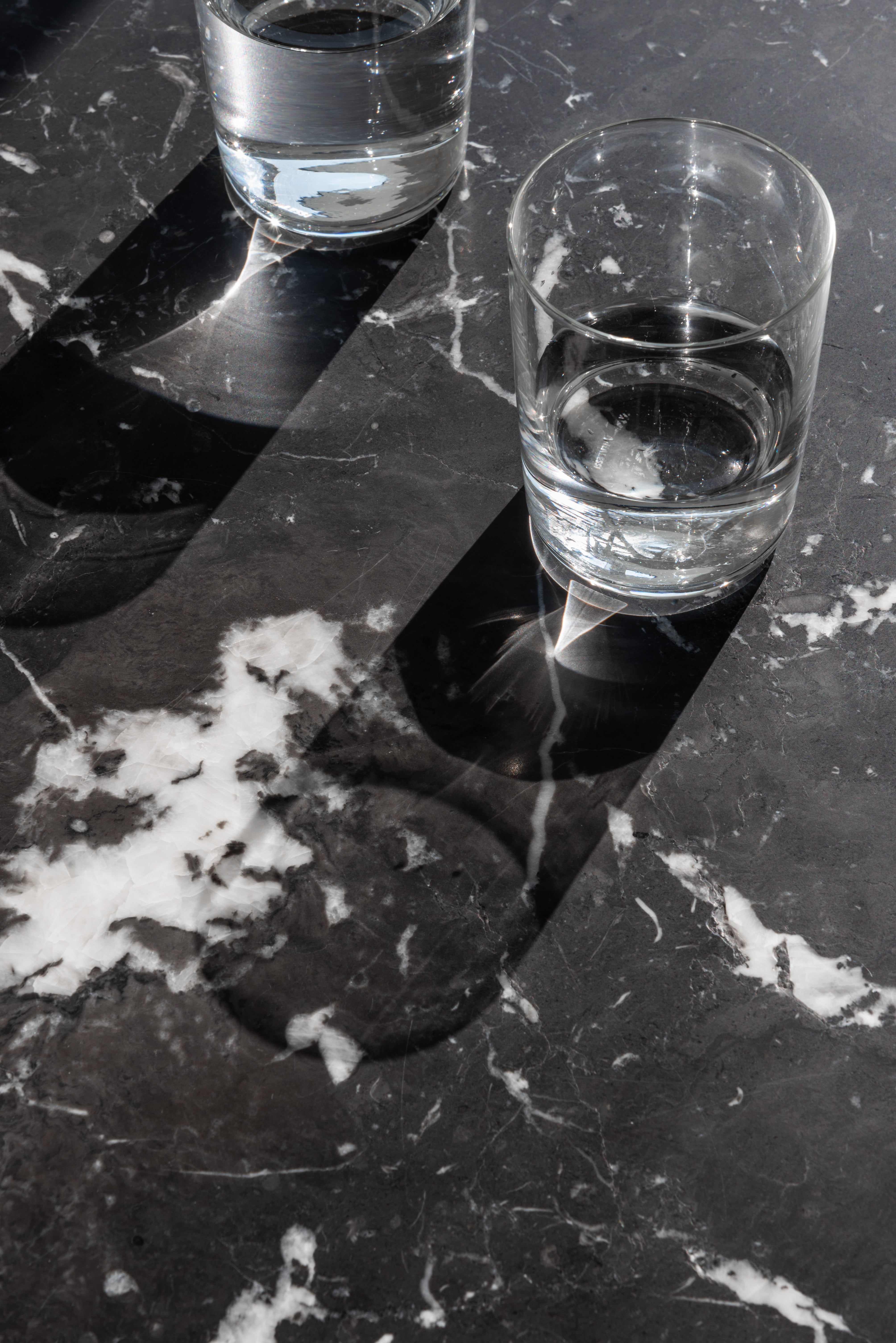 BRUT runder Tisch aus schwarzem Marmor mit rotem Sockel