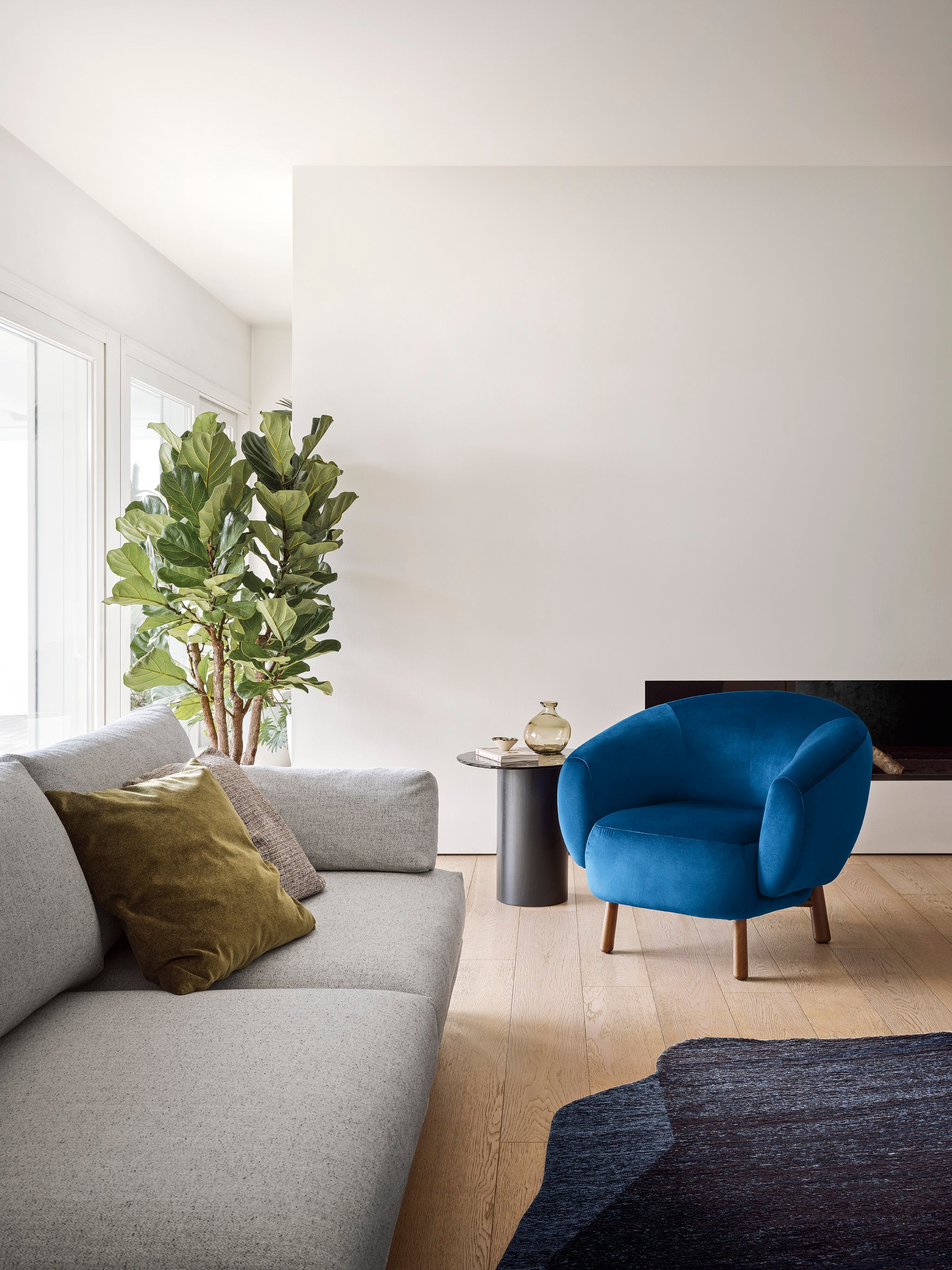 Upholstered RIO armchair with a dark wooden base