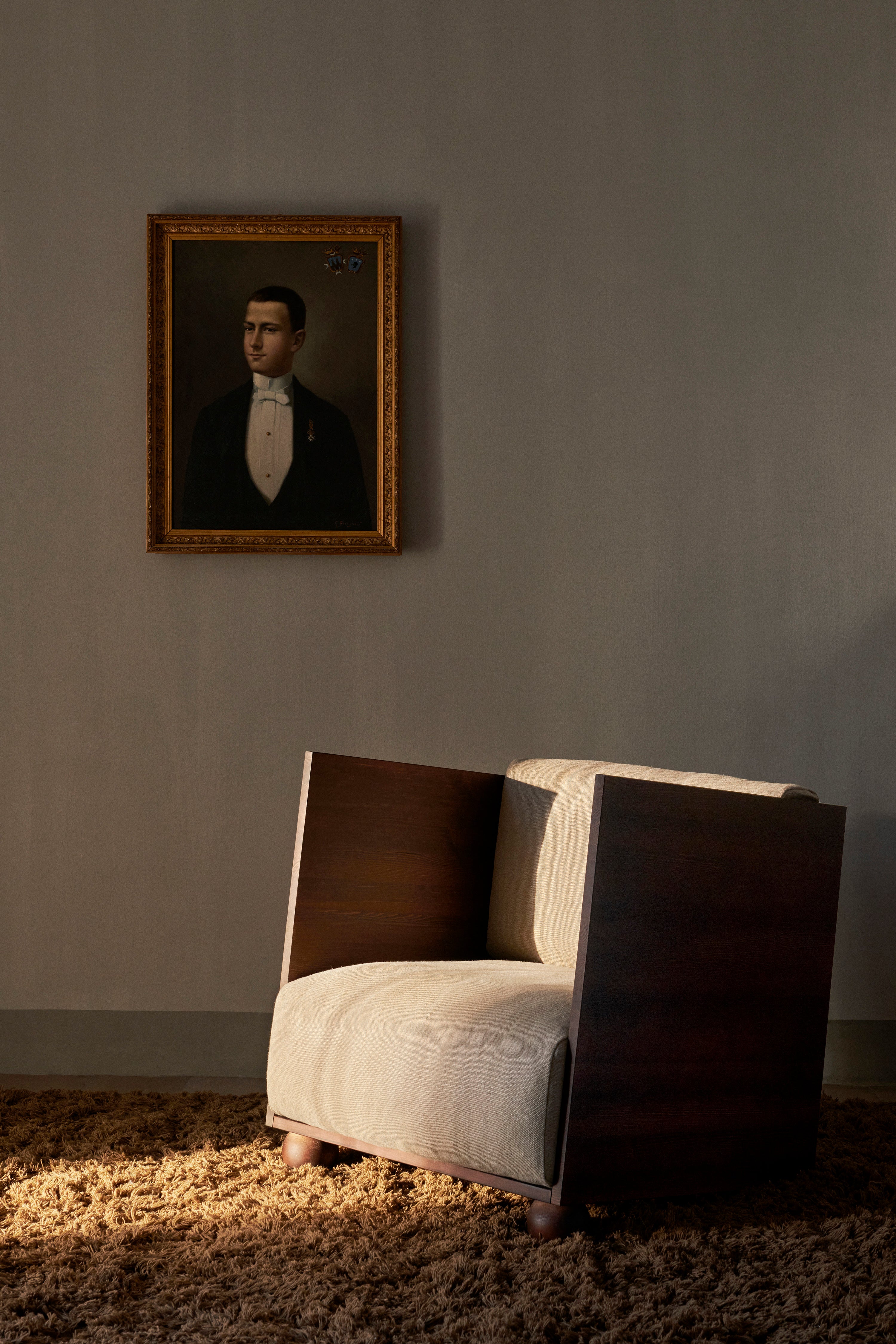 RUM beige armchair with a dark brown wooden base