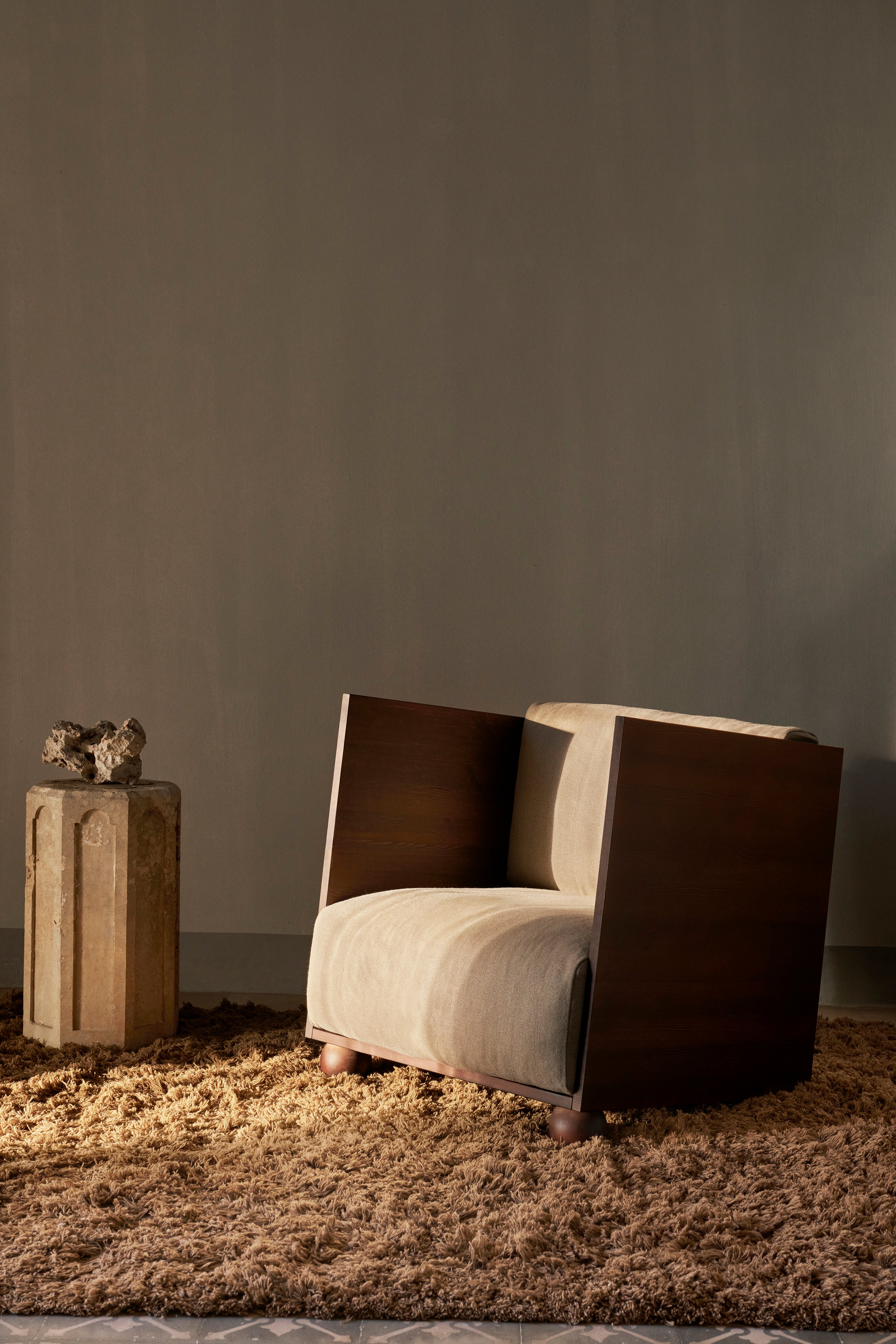 RUM beige armchair with a dark brown wooden base