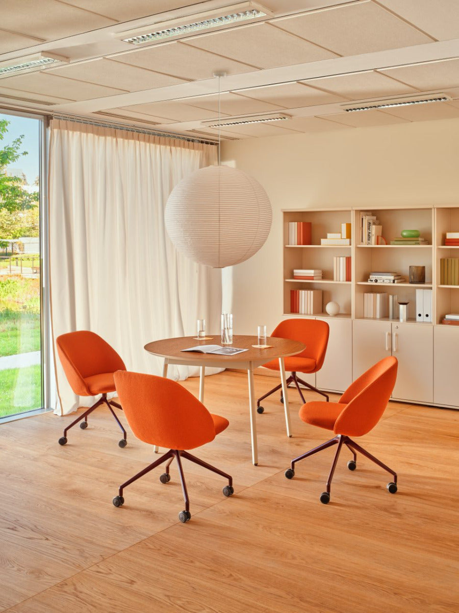 Rotable armchair with low backrest metal parallel base with wheels to a soft surface