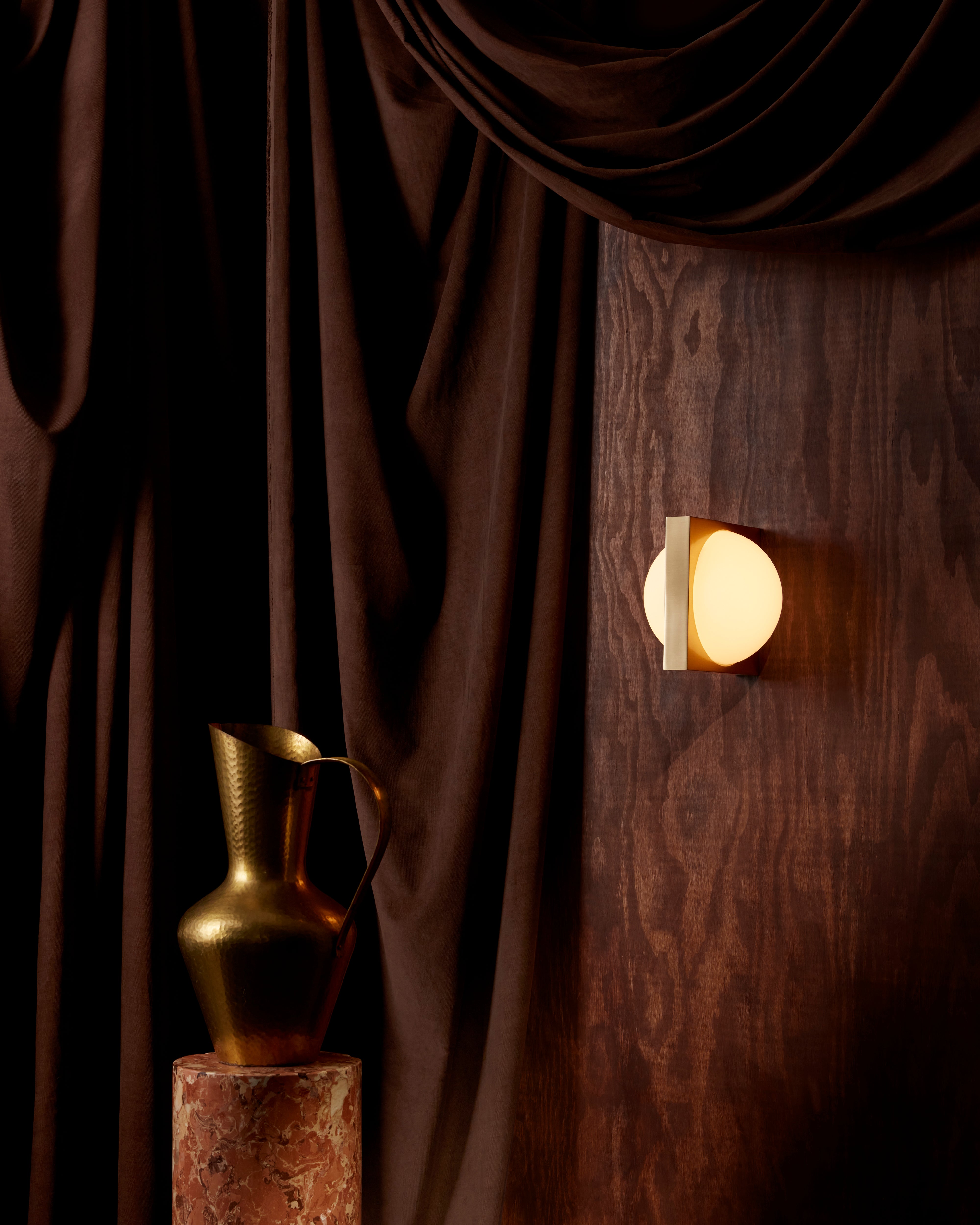 SOLSTICE wall lamp with an opal shade and brass accents.