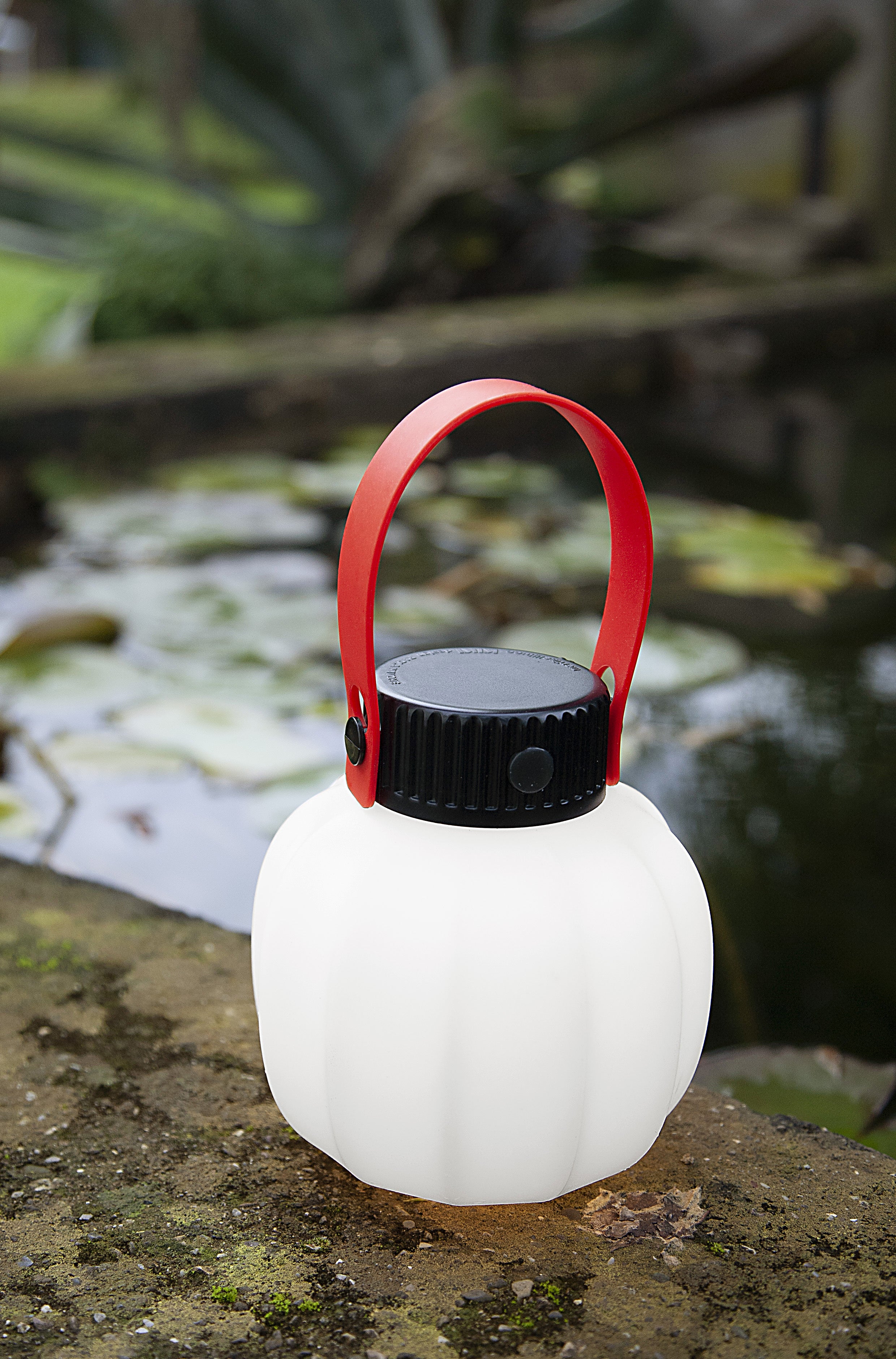 Portable outdoor lamp KIKI in white with a silicone handle.