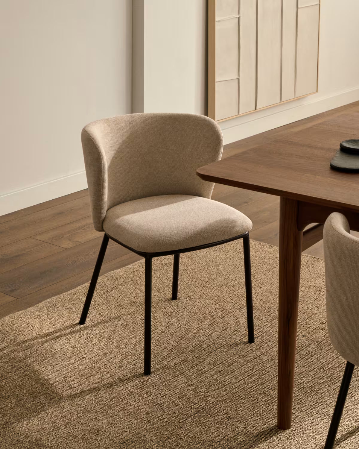 A chair in the ciselia beige szenil fabric with a black base