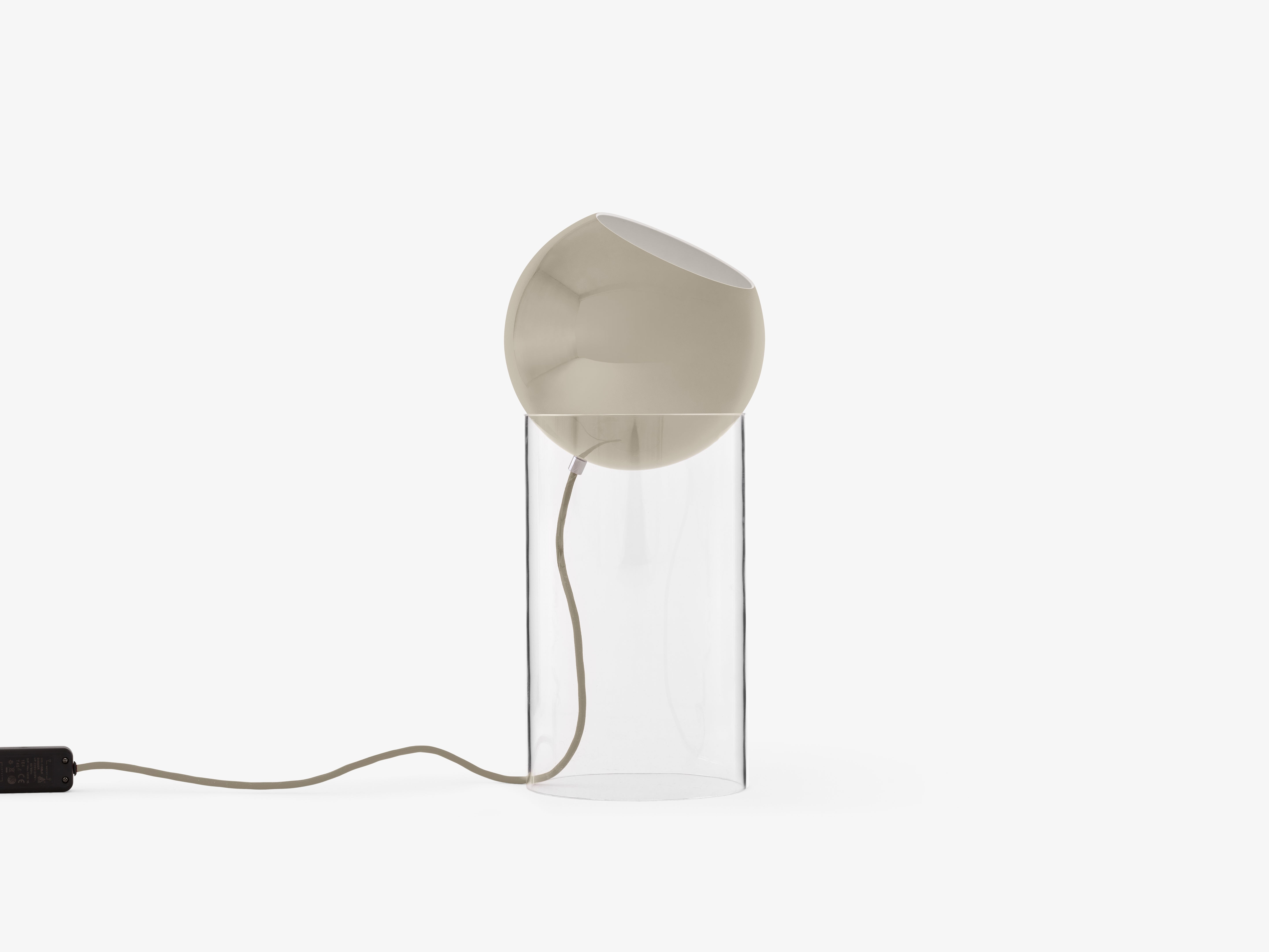 TOPAN table lamp with a gray-beige shade and a transparent base.