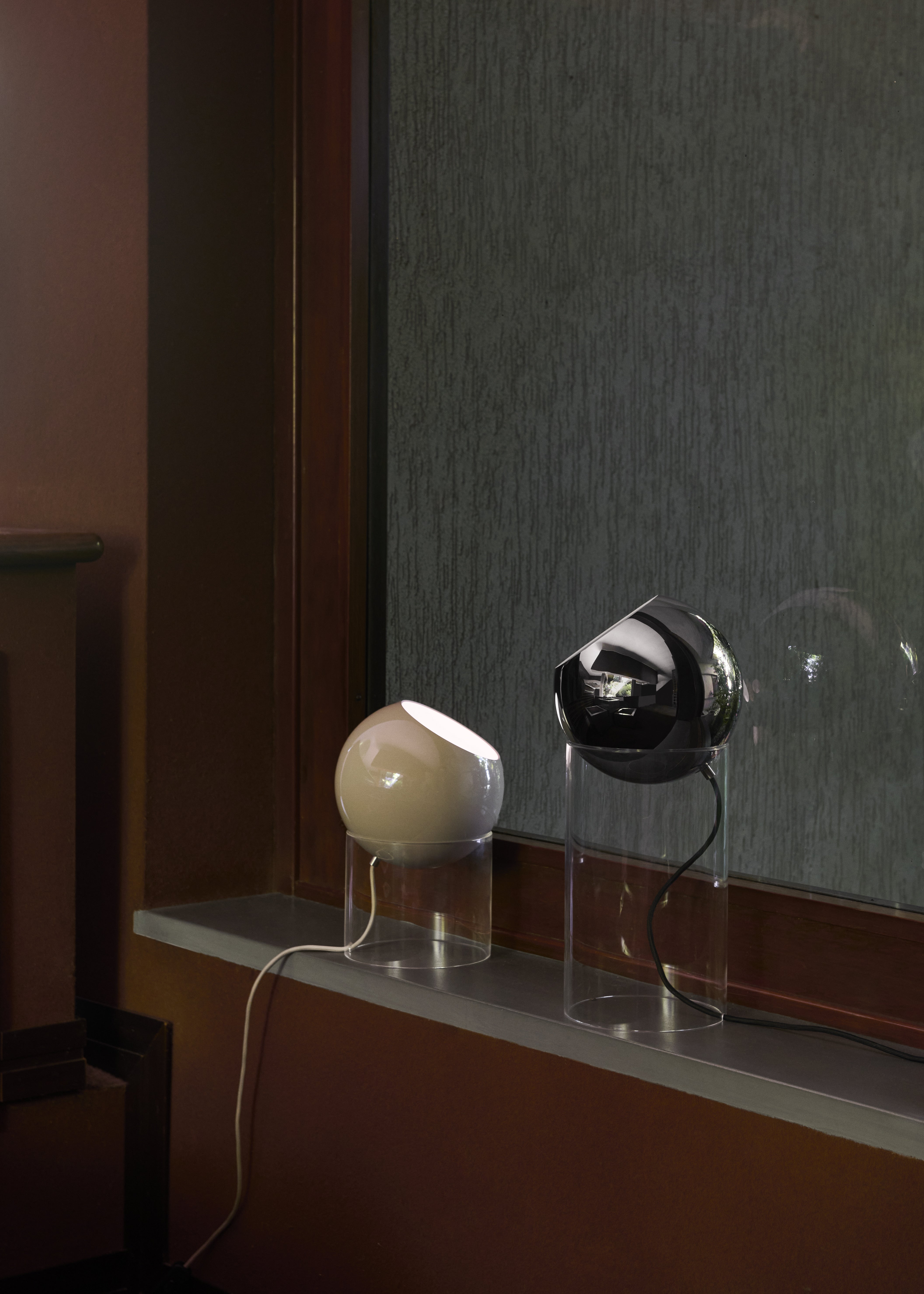 TOPAN table lamp with a gray-beige shade and a transparent base.