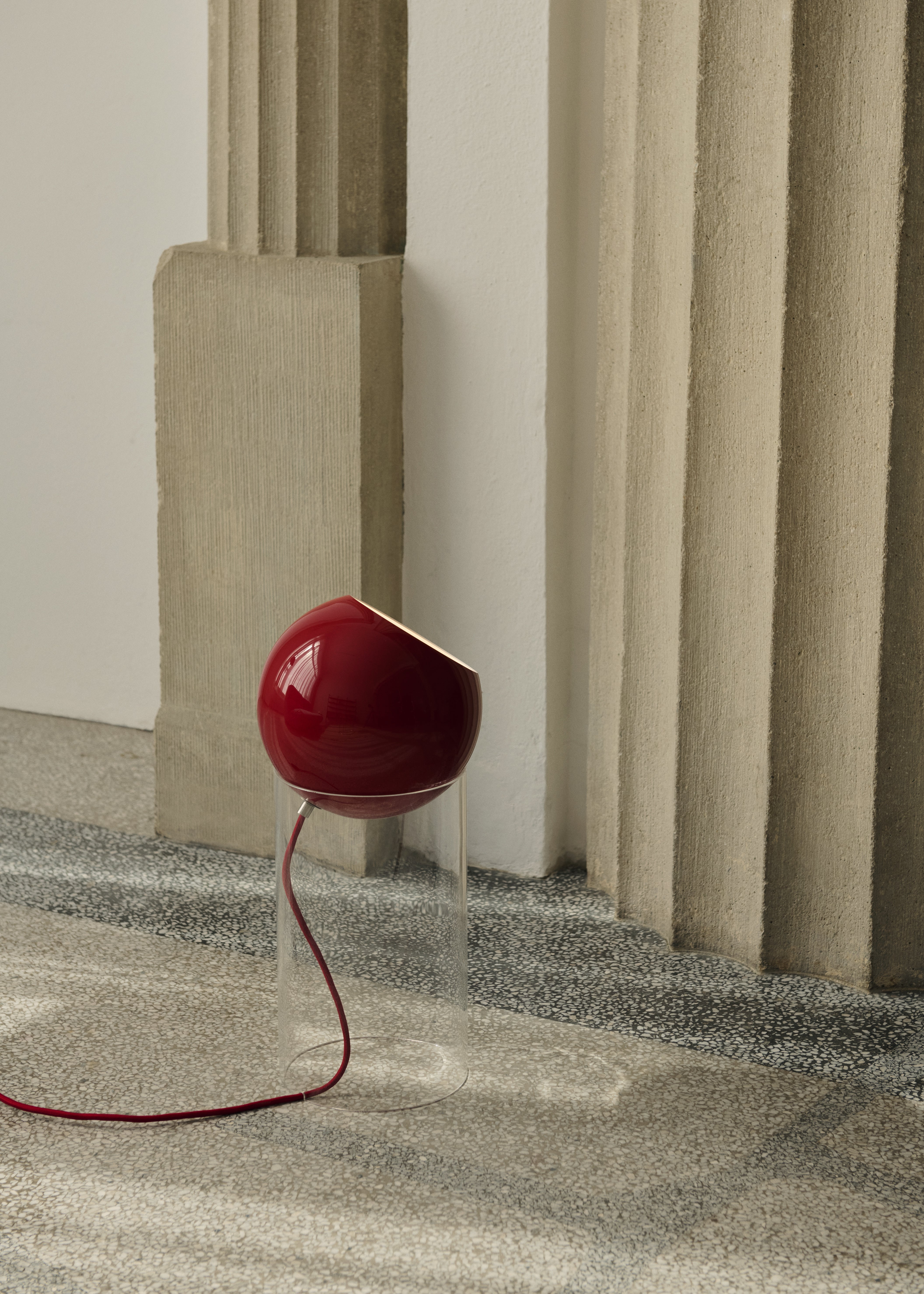 TOPAN table lamp with a red shade and transparent base.