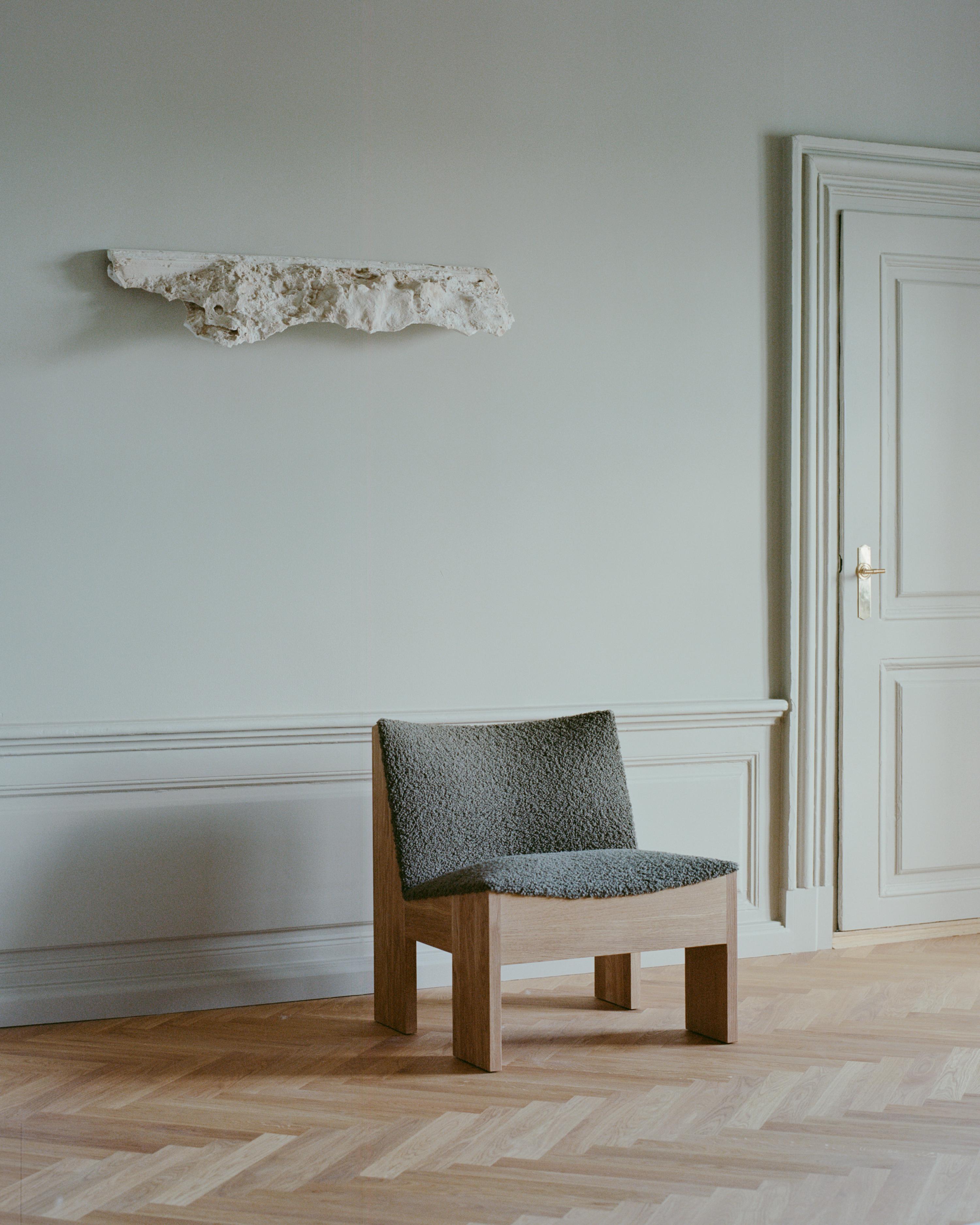 Tenon upholstered armchair with an oak base