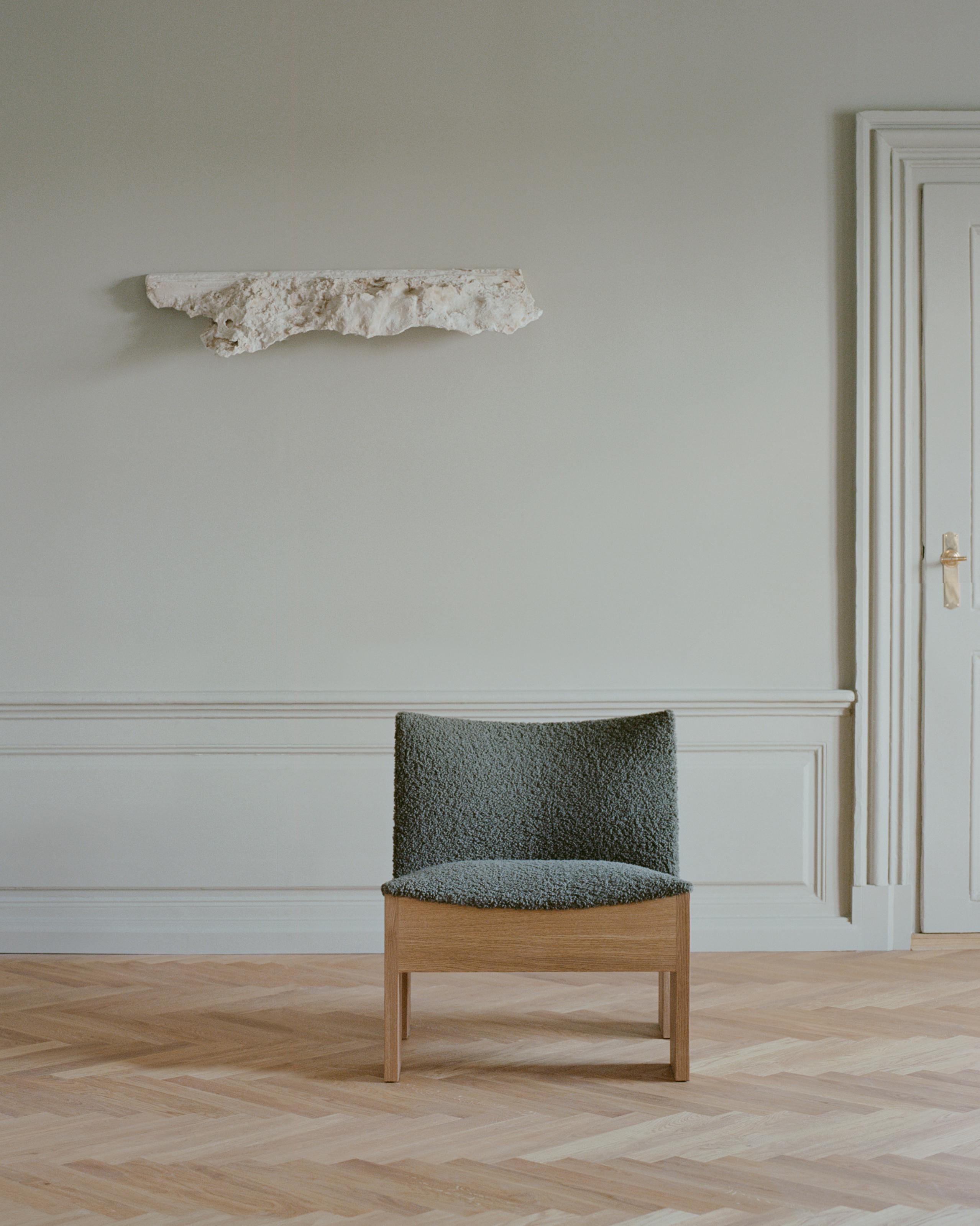 Tenon upholstered armchair with an oak base