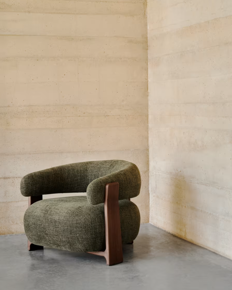 Green green armchair with a dark wooden base