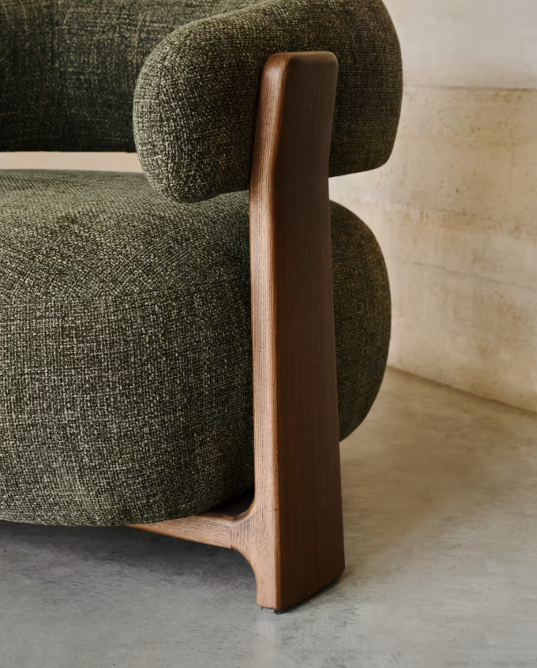 Green green armchair with a dark wooden base