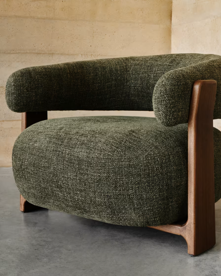 Green green armchair with a dark wooden base