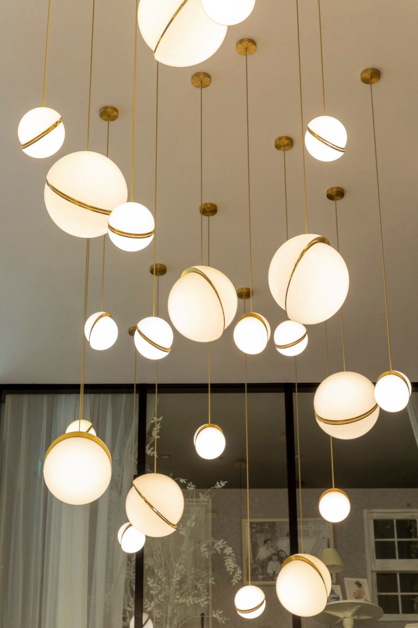 CRESCENT pendant lamp with an opal shade and brass accents.