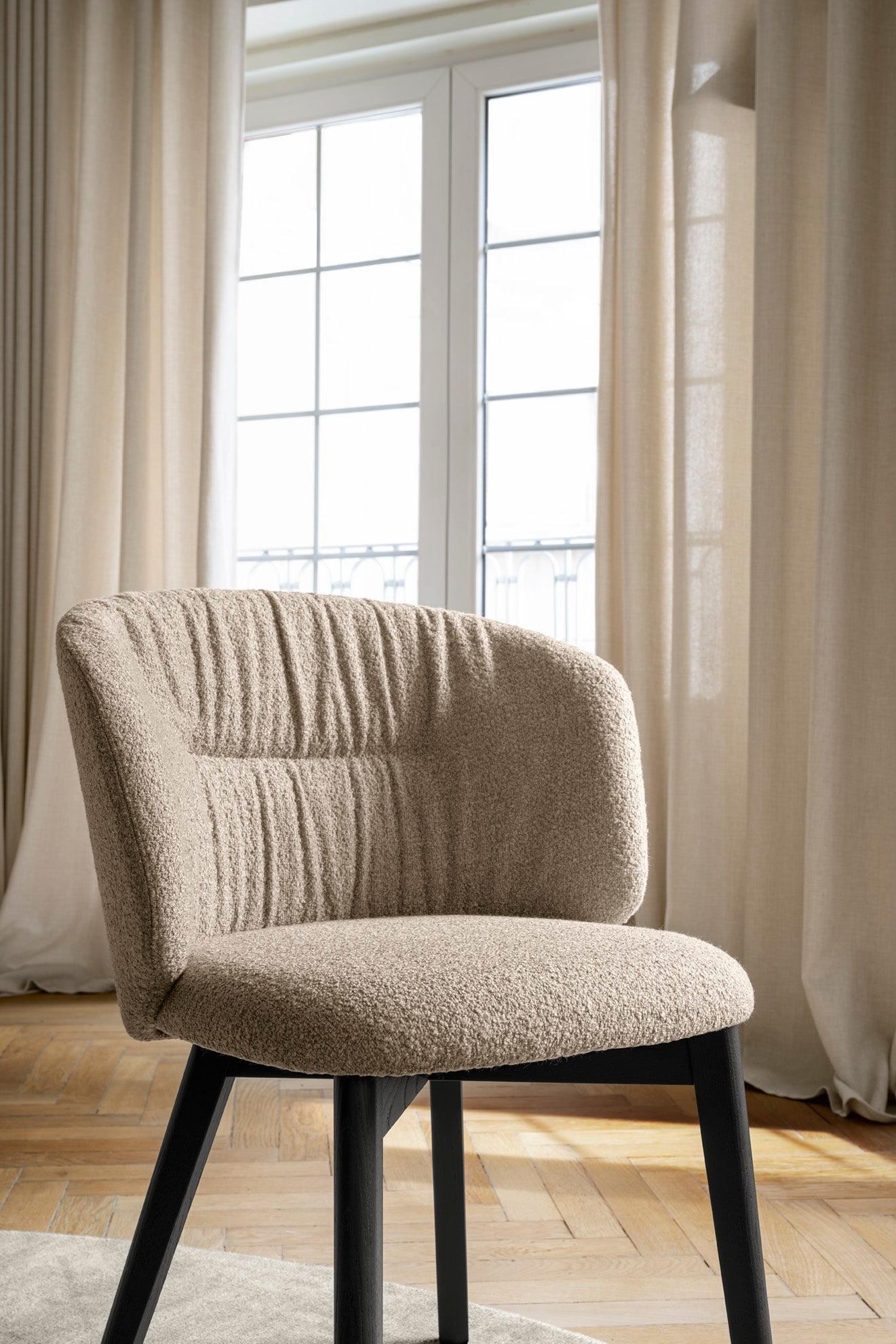 Upholstered SWEEL chair with a dark wooden base