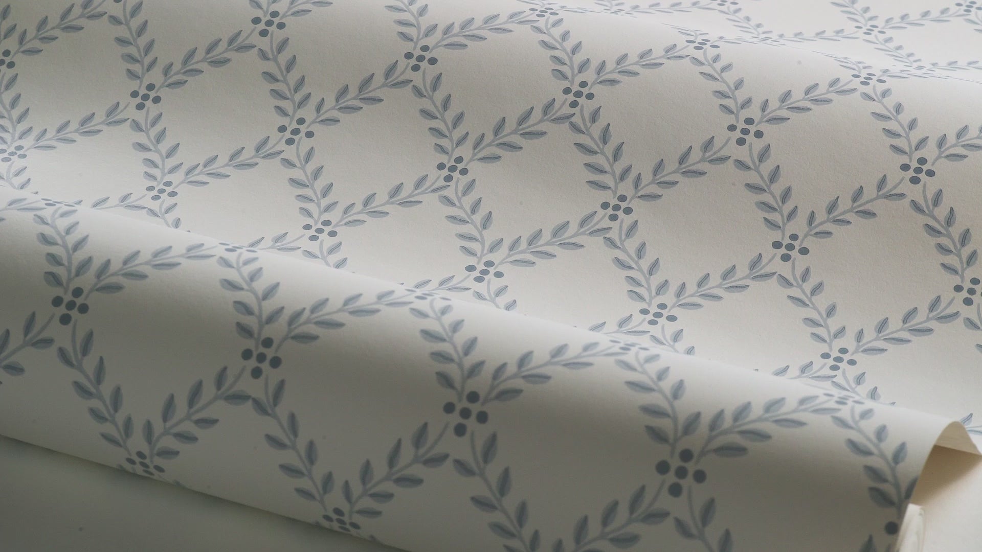 Wallpaper with a geometric plant pattern of TRELLIS LEAVES in cream with blue
