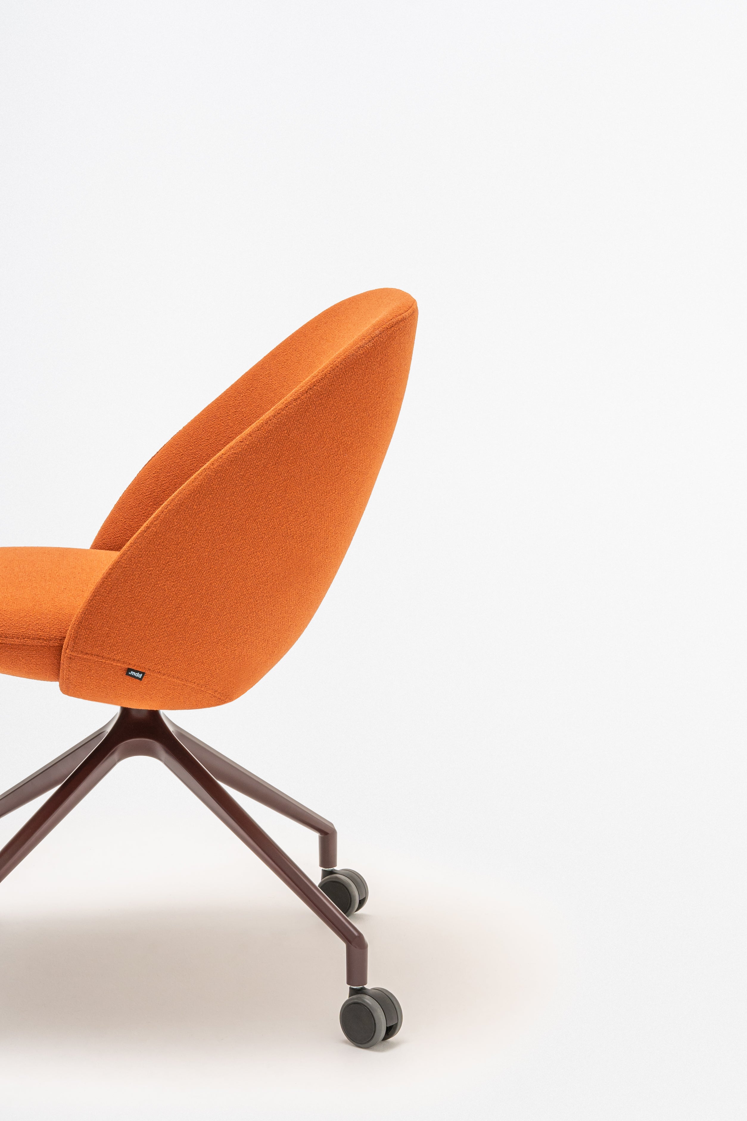 Rotable armchair with low backrest metal parallel base with wheels to a soft surface