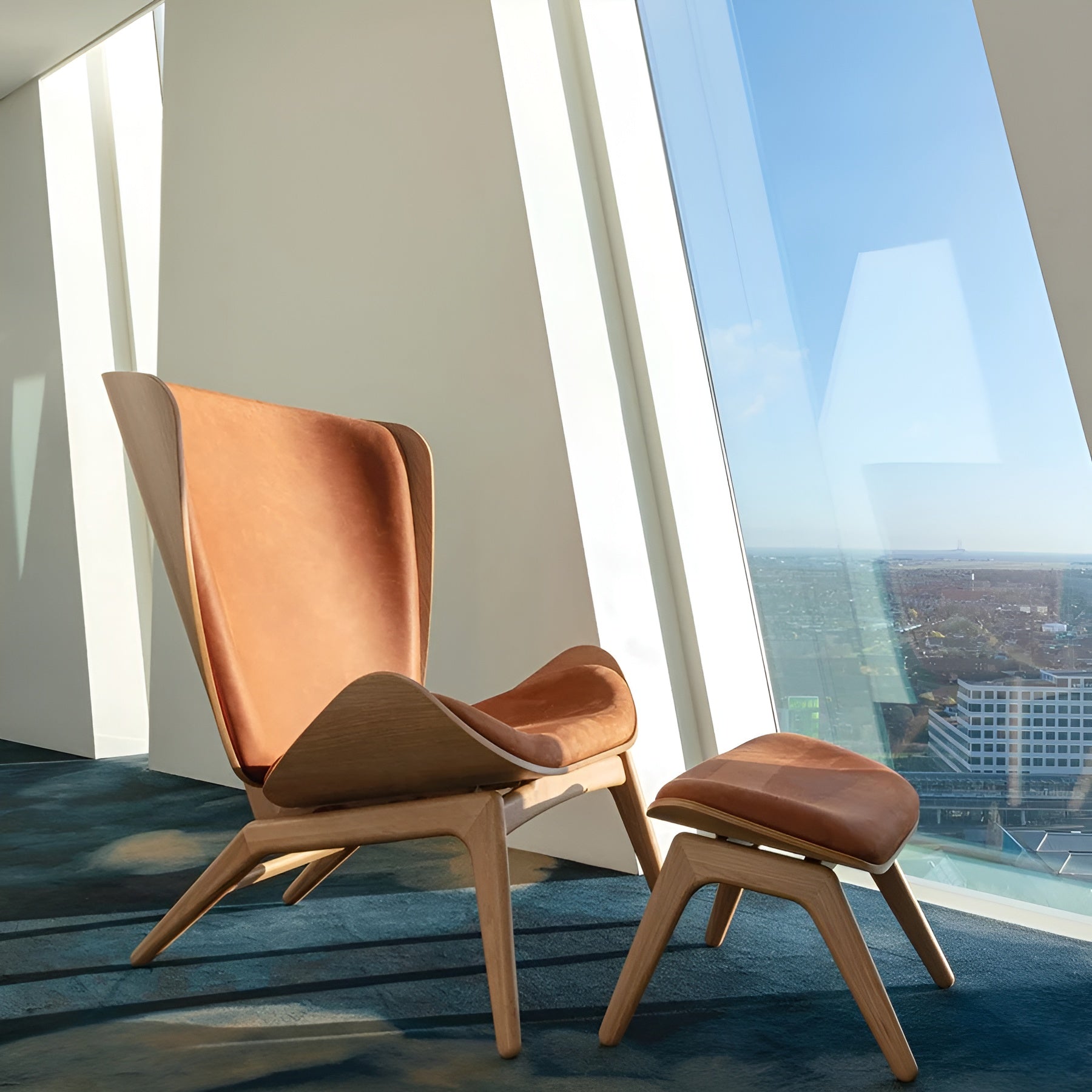 READER footstool in cognac leather with a black base